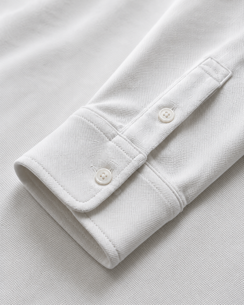 Puños y acabados del polo de manga larga con tapeta abotonada
